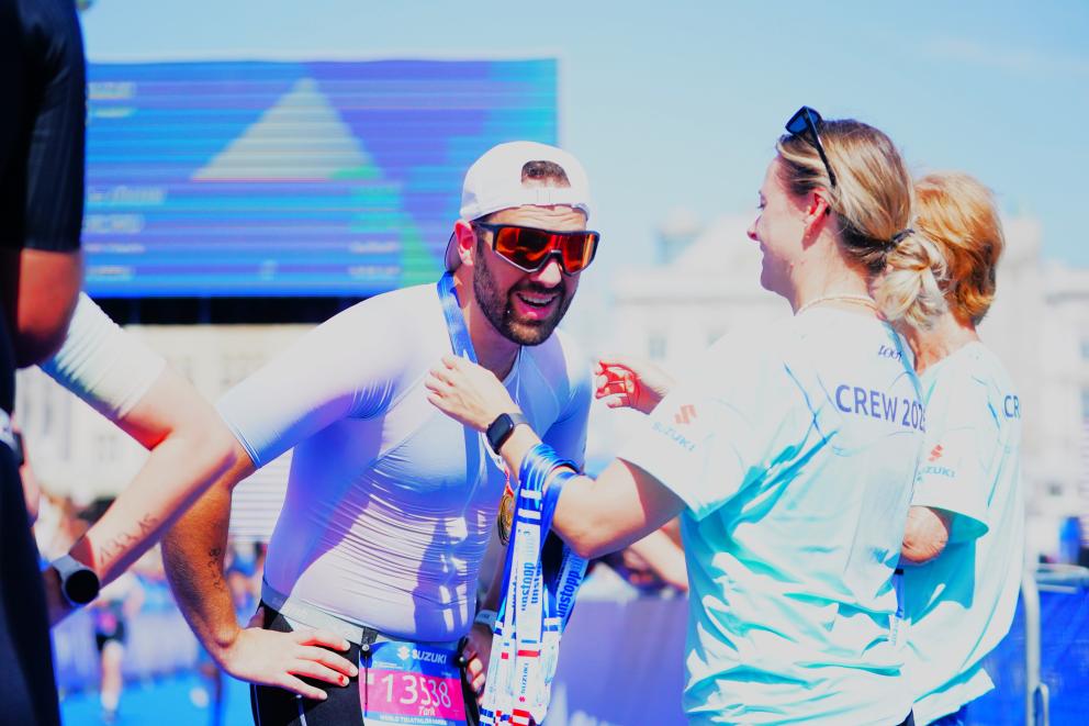 Ein Finisher erhält von der Crew seine Finisher-Medaille.