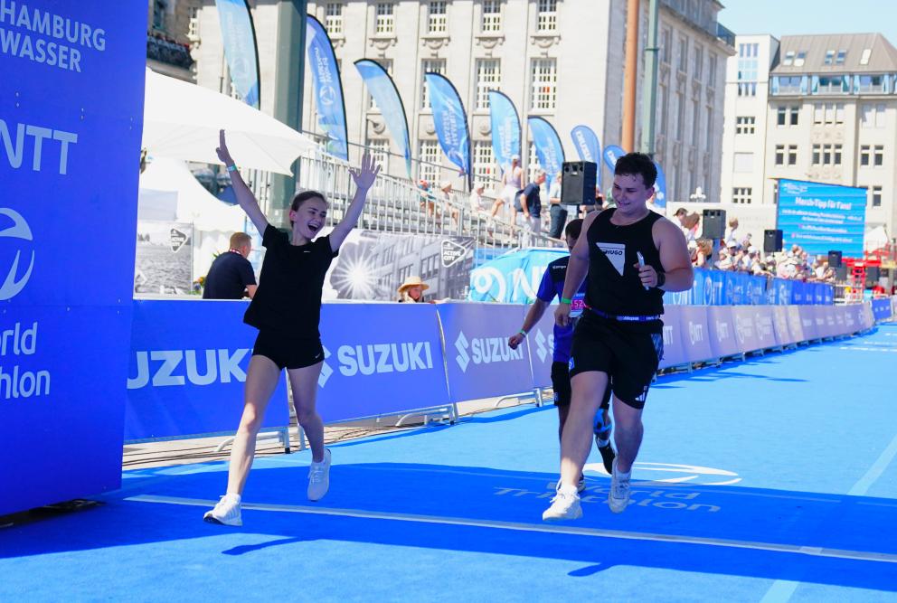 Freude im Ziel auf dem blauen Zielteppich beim Suzuki World Triathlon Hamburg.