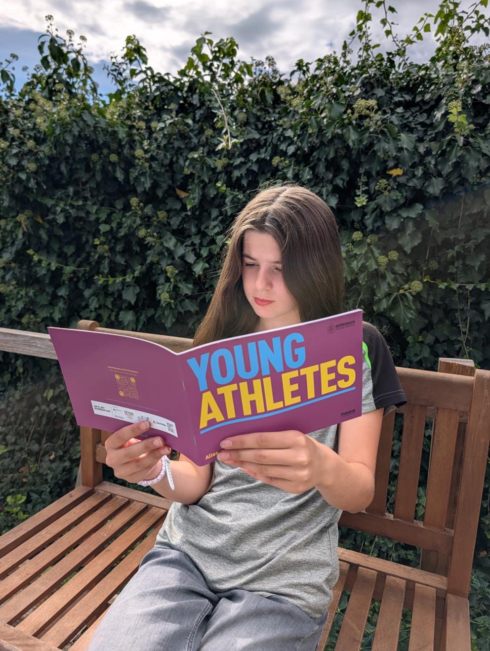 Eine junge Athletin liest die NADA-Broschüre „Young Athletes".