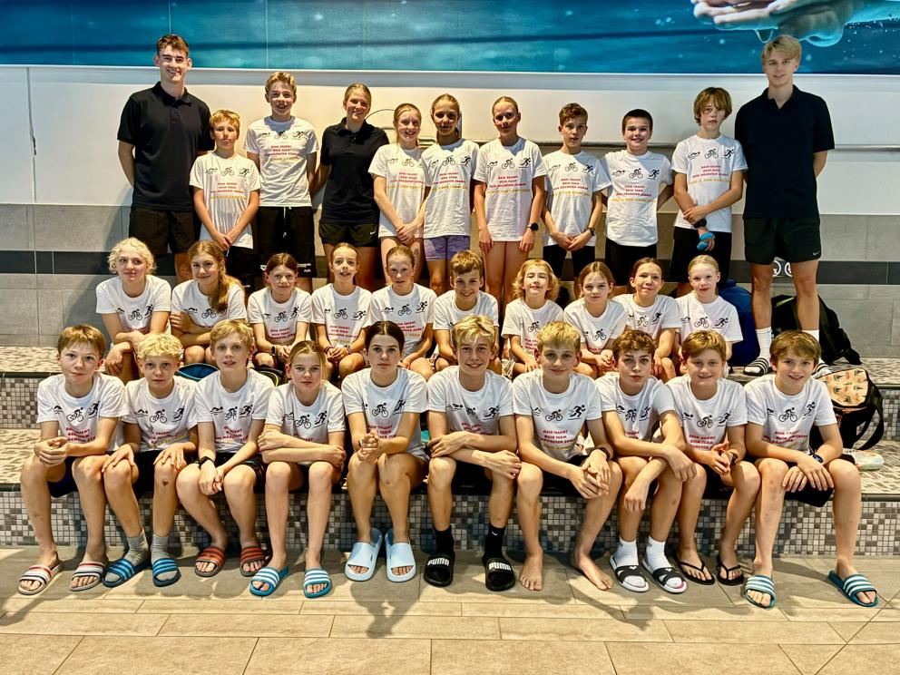 Gruppenfoto der 29 Teilnehmenden in den Camp-Shirts mit dem Trainerteam im Schwimmbad Itzehoe.